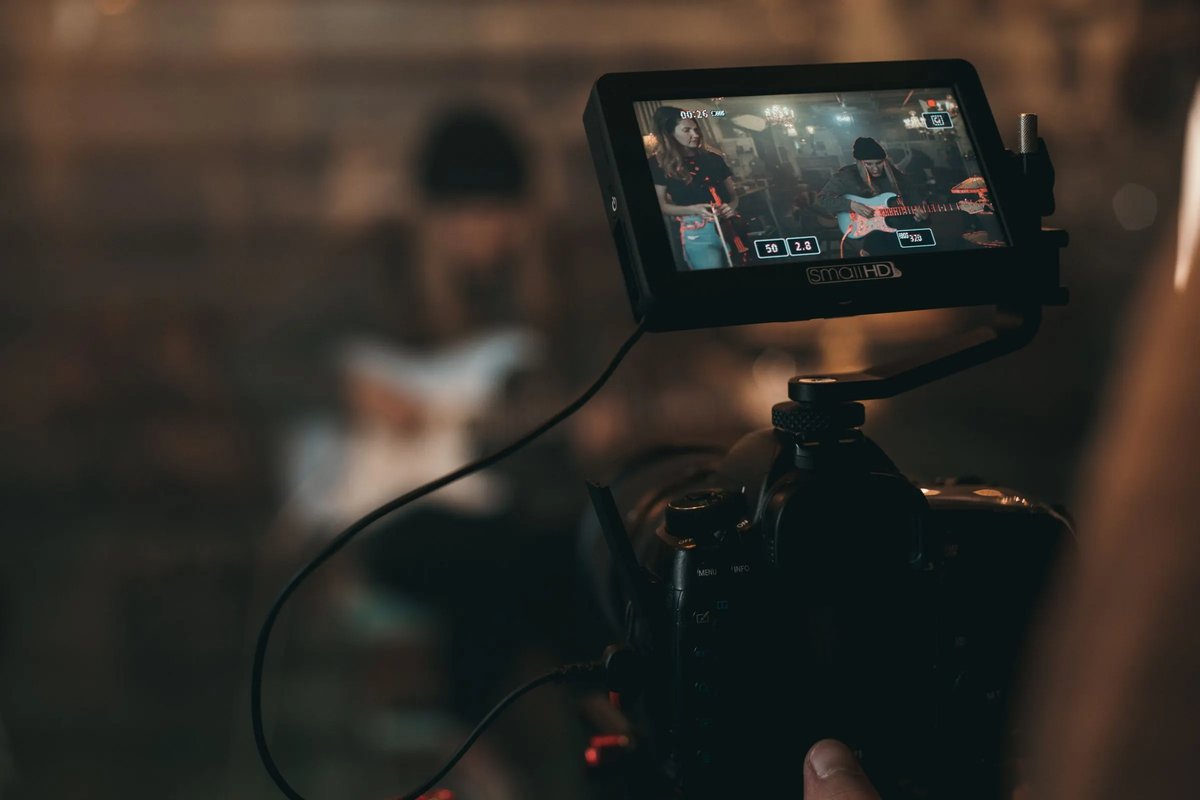Videographer working with cinema camera and studio lighting at Musicians World
