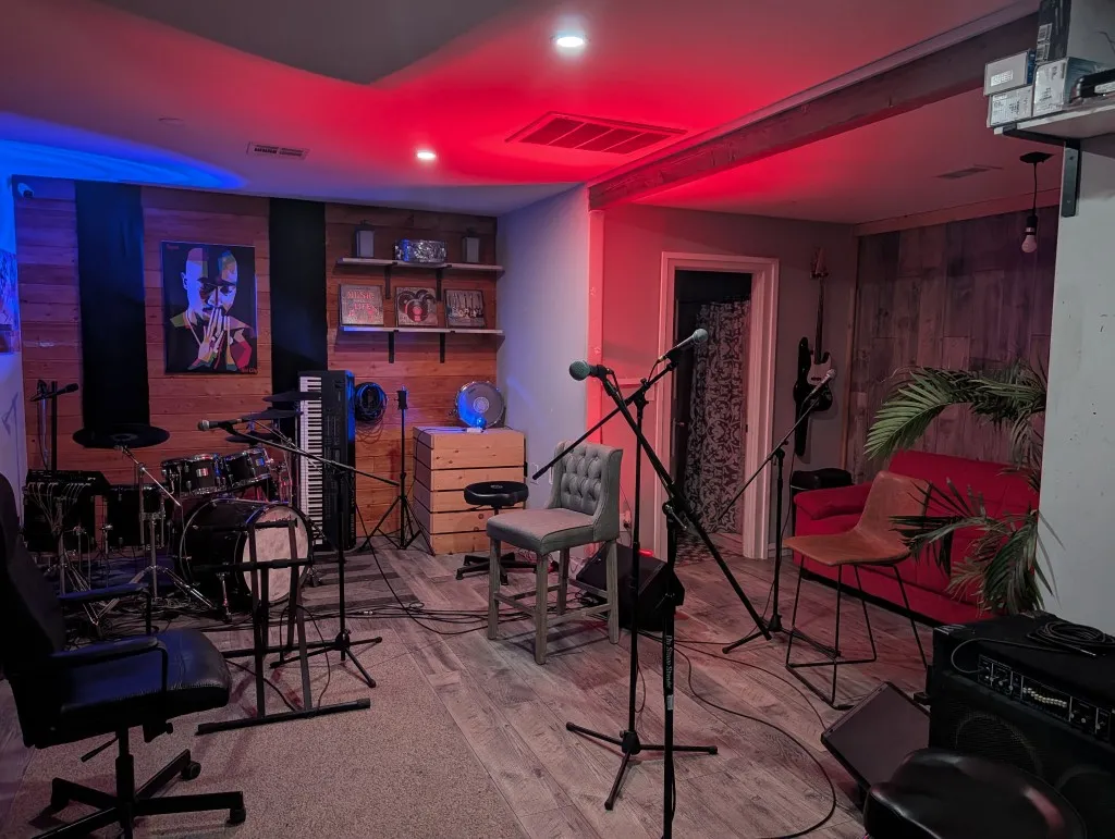 Studio A session floor with drums, mics, seating, and red-blue wash lighting